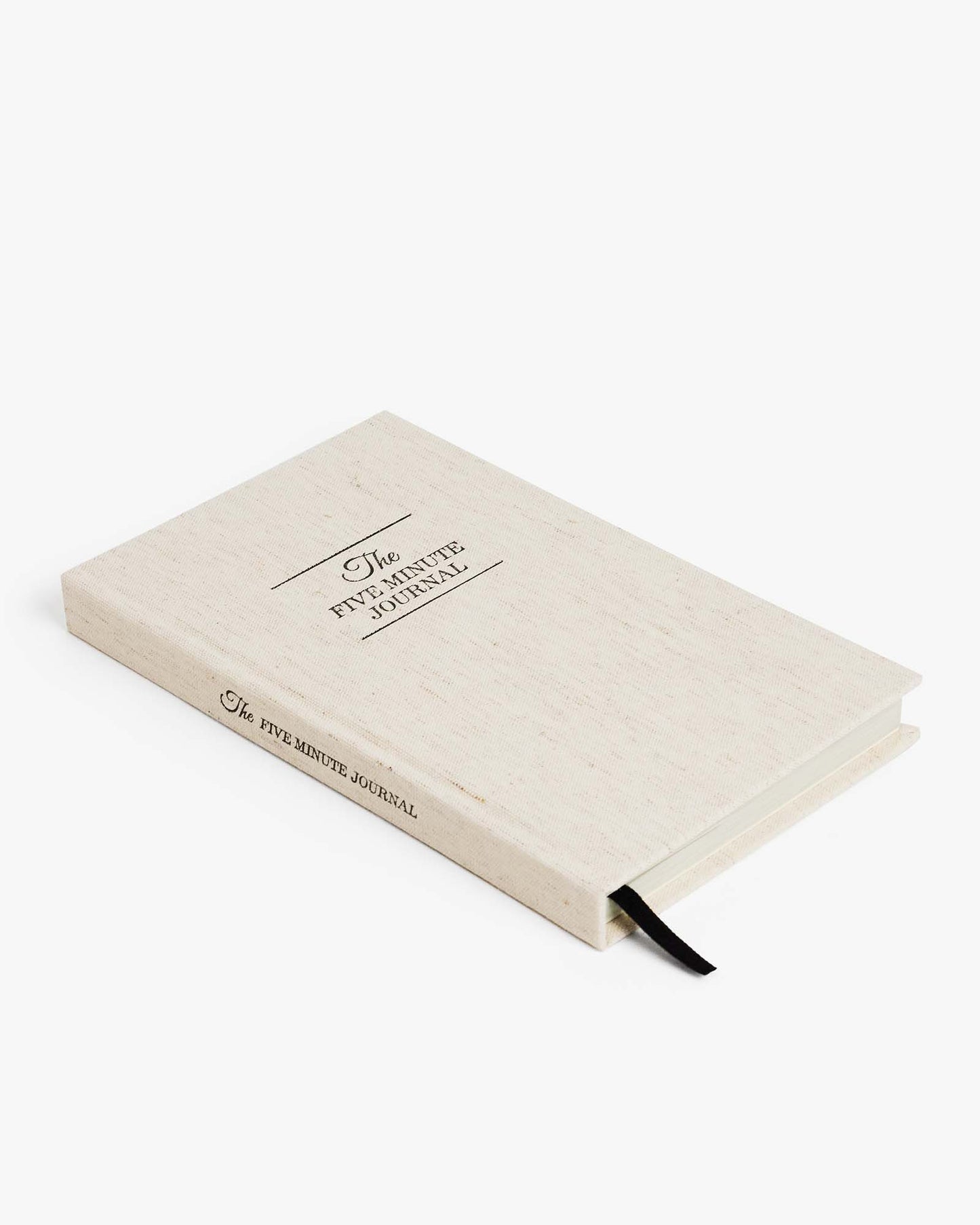 The Five Minute Journal by Intelligent Change in a textured linen cover, open to a mindfulness journal with writing prompts.
