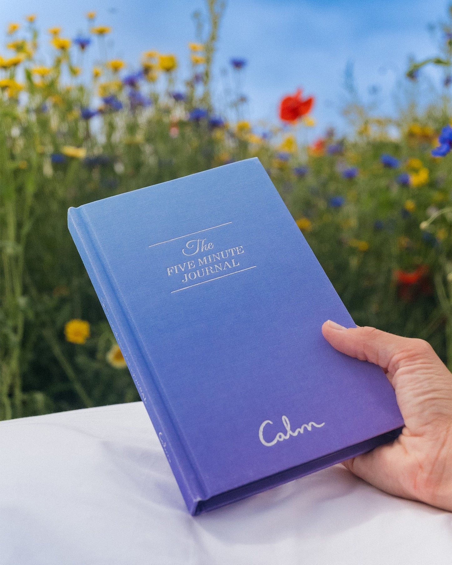 Open Calm x The Five Minute Journal by Intelligent Change, featuring a sleek mindful journaling book on a clean surface.