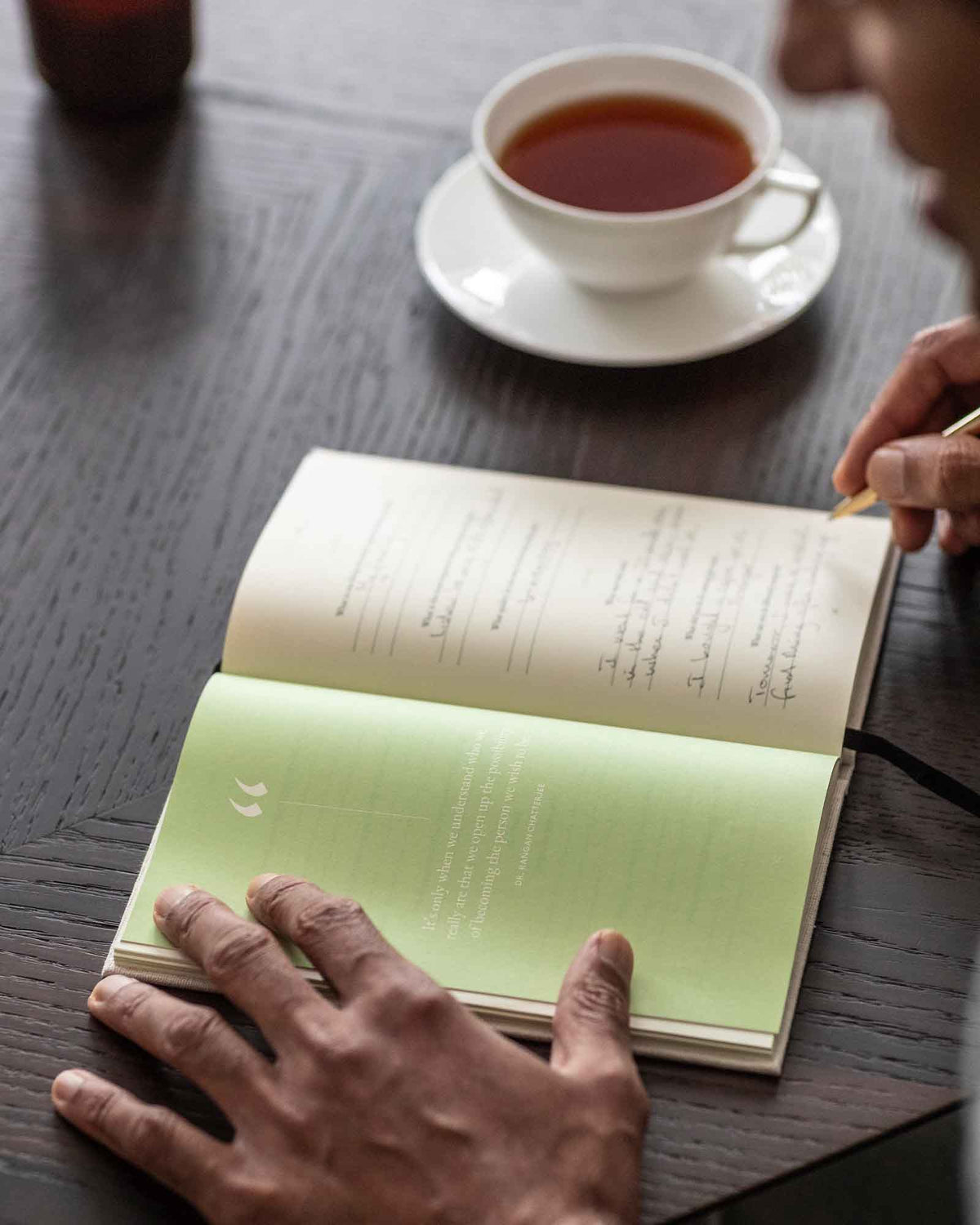 Green The Three Question Journal by Intelligent Change, mindfulness journal with open pages showing prompts for reflection and self-awareness.