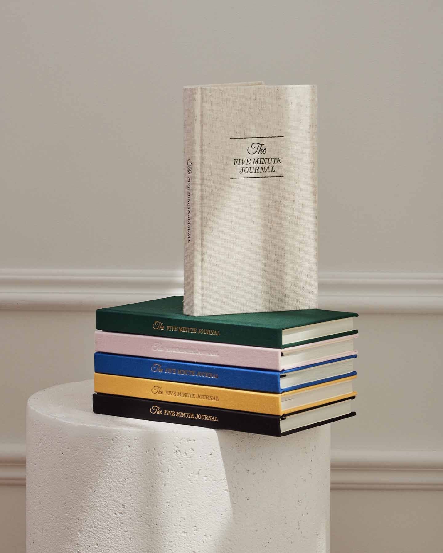 The Five Minute Journal original linen mindfulness journal with colorful cover pages and lined pages for daily reflections.