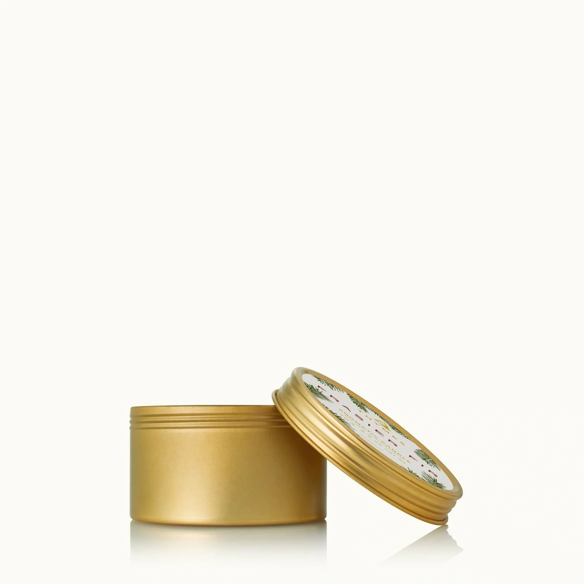 Thymes Frasier Fir candle in a 6.5 oz tin with a gold lid, featuring a festive fir scent and decorative design.