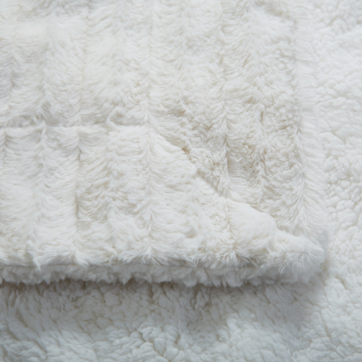 Tache White Ivory Polar Faux Fur with Sherpa Throw Blanket draped over a sofa for cozy home decor.