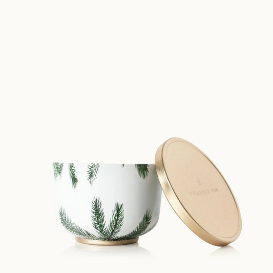 Thymes Frasier Fir candle in a 6.5 oz tin with a gold lid, featuring festive green and white design and a fir tree scent.